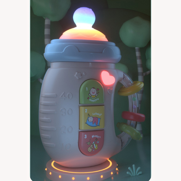 Raminantis pieno buteliuko formos barškutis su garsais ir šviesomis